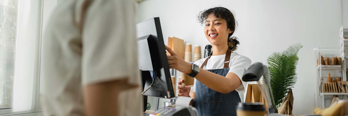 serveuse à la caisse qui doit se conformer à la nouvelle obligation de certification des logiciels de caisse