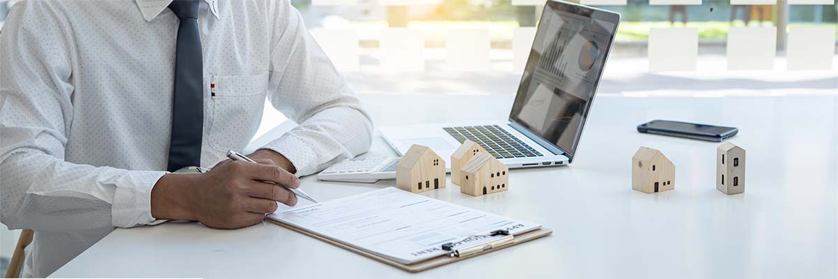 Homme d'affaires en chemise en train de remplir un formulaire dans le cadre de sa déclarations des biens immobiliers
