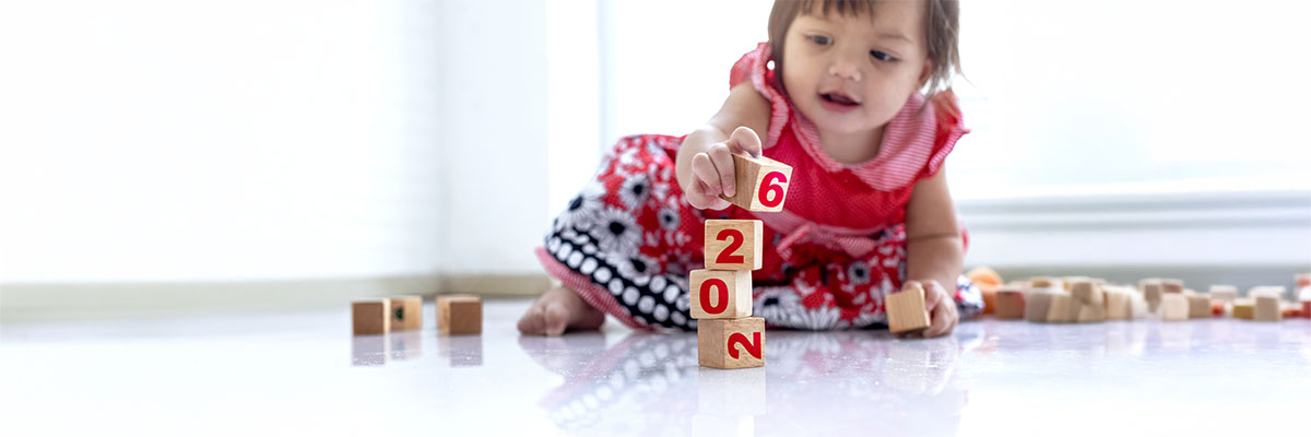 bébé jouant avec des cubes avec inscrit "2026" pour symboliser le nouveau congé de naissance intrégé à la loi de financement de la sécurité sociale 2026