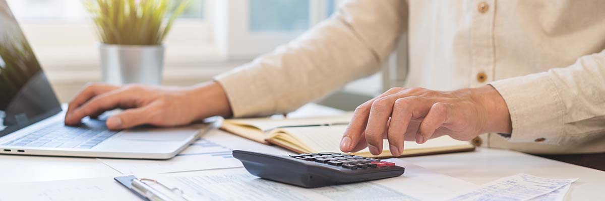 personne qui tape sur sa calculatrice pour calculer les frais de son entreprise selon le barème 2026 des frais professionnels