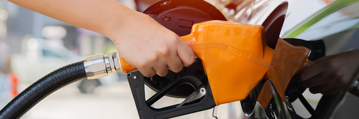 main mettant de l'essence dans une voiture de service car a bénéficié d'aides carburant pour les entreprises