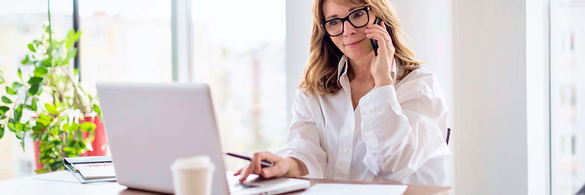 femme au téléphone devant son ordinateur s'informant sur la s TVA du régime fin de la CA12 due à la réforme du régime simplifié de TVA en 2027
