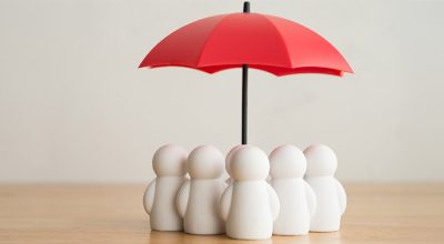 parapluie rouge au-dessus d'un groupe de personnages blancs représentant l'assurance professionnelle obligatoire