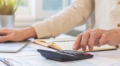 personne qui tape sur sa calculatrice pour calculer les frais de son entreprise selon le barème 2026 des frais professionnels