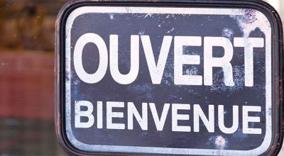plaquette marquée dessus "ouvert bienvenue" afin de montrer que le commerce peut ouvrir le dimanche