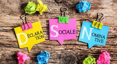 papiers de couleur posés sur une table en bois indiquant ce qu'est la DSN
