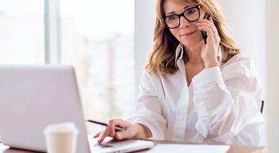 femme au téléphone devant son ordinateur s'informant sur la s TVA du régime fin de la CA12 due à la réforme du régime simplifié de TVA en 2027