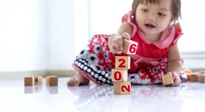 bébé jouant avec des cubes avec inscrit "2026" pour symboliser le nouveau congé de naissance intrégé à la loi de financement de la sécurité sociale 2026