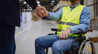 employeur qui serre la main d'une personne en fauteuil roulant car elle vient de l'embaucher grâce aux aides Agefiph 2025.